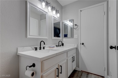 Full bath featuring double vanity, wood finished f