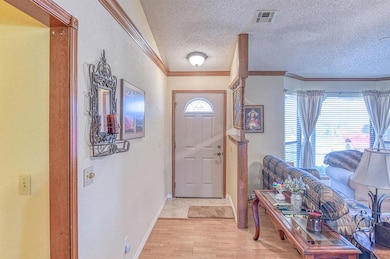 Entrance foyer featuring crown molding, a textured