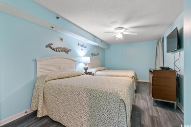 Bedroom with wood finished floors, a textured ceiling, and a ceiling fan