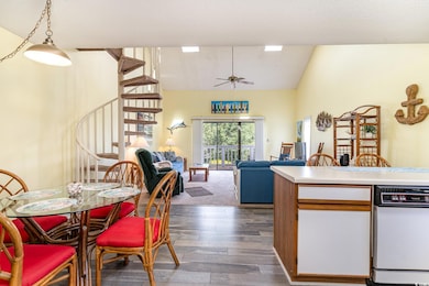 Dining room with dark wood-style flooring, vaulted ceiling, a ceiling fan, stairs, and a textured ceiling