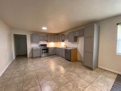 Kitchen featuring gray cabinets, appliances with stainless steel finishes, light countertops, and light tile patterned floors