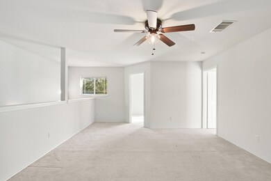 Carpeted spare room with a ceiling fan and baseboards