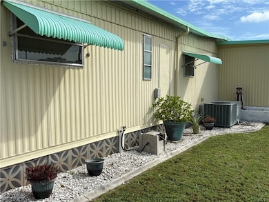 View of side of home featuring a central AC unit and a yard