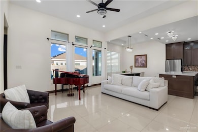 Living area with recessed lighting, light tile patterned flooring, and a ceiling fan
