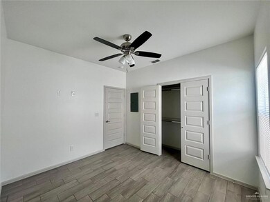 Unfurnished bedroom with wood finished floors, electric panel, a closet, and a ceiling fan