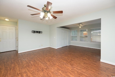 Spare room with dark wood-type flooring, a textured ceiling, and a ceiling fan