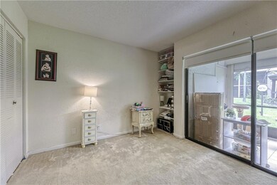 Second bedroom with carpet flooring and sliders to