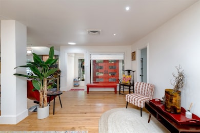 Sitting room with light wood finished floors and recessed lighting