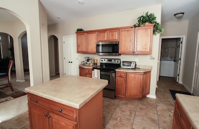 Kitchen with washer / dryer, a toaster, brown cabi