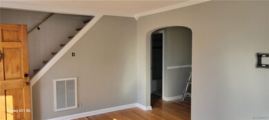 Family room with stairs to 2nd floor and arched opening to dining kitchen area.