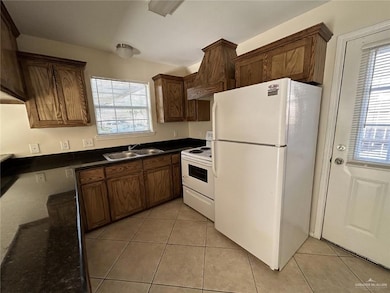 Kitchen with a sink, a wealth of natural light, and white appliances