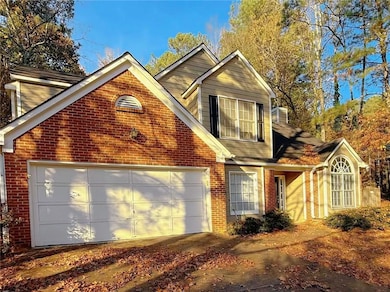 Traditional-style house featuring brick siding and an attached garage