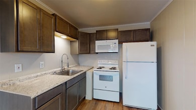 Kitchen featuring a sink, light countertops, white