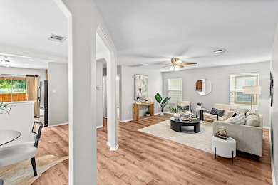 Living area with visible vents, a ceiling fan, ba