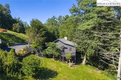 Back view of the main house features a deck with sweeping mountain views, plus additional parking at the guest cottage.