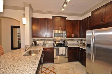 Kitchen featuring light tile patterned flooring, decorative backsplash, sink, and stainless steel appliances