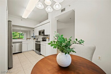Kitchen with a chandelier, crown molding, light countertops, white cabinets, and light tile patterned floors