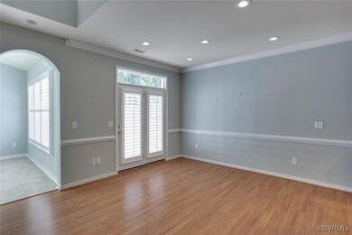 Empty room featuring arched walkways, crown moldin
