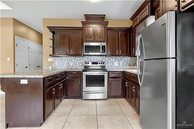 Kitchen with stainless steel appliances, open shelves, a peninsula, tasteful backsplash, and dark brown cabinets