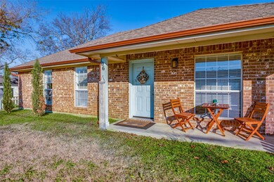 Doorway to property with a lawn and a patio