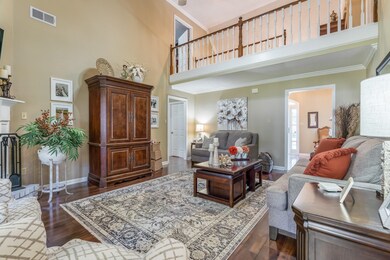 Living room with a high ceiling, crown molding, an