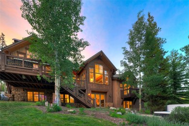 Back of property at dusk with stone siding, stairw