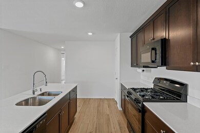 Kitchen with a sink, light wood finished floors, b