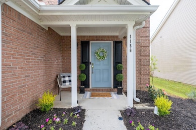 Picture-perfect entrance featuring a stylish light blue door, set against a classic brick facade with contrasting dark shutters