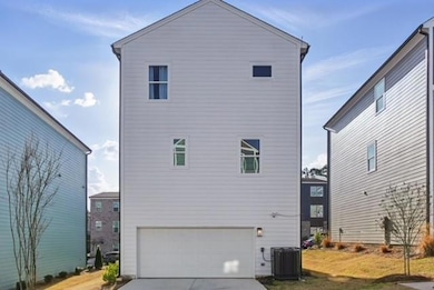 Rear view of property with a garage, cooling unit,