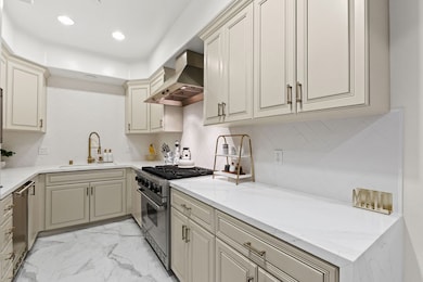 Calacatta style quartz countertops with waterfall edge + stainless steel appliances anchored by a 6 burner Viking gas range.