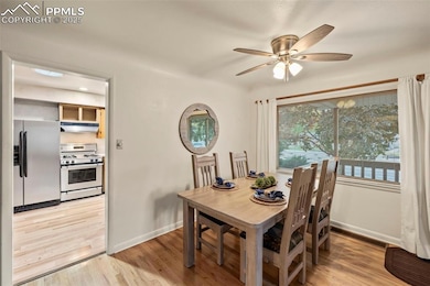 Dining space with baseboards, light wood-style flooring, and ceiling fan