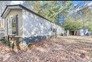 View of side of home with a storage unit