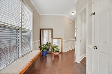 Corridor featuring crown molding, wainscoting, woo