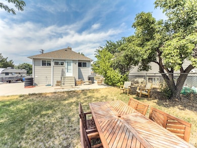 Rear view of property featuring a patio, a shingled roof, and entry steps