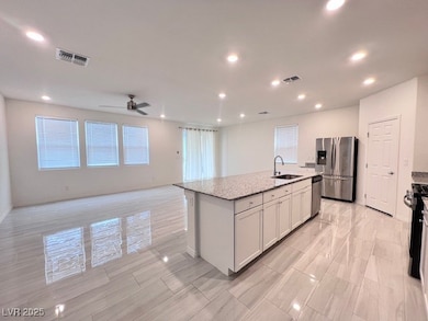 Kitchen featuring a center island with sink, stain