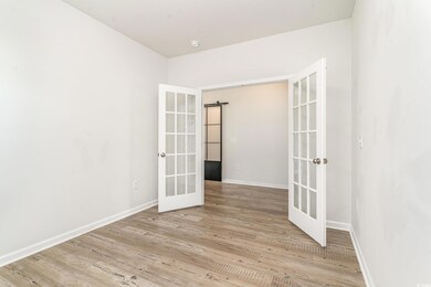 Empty room featuring french doors, baseboards, and wood finished floors