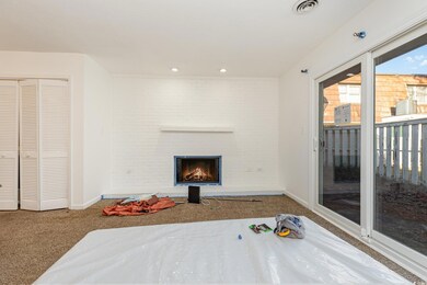 Carpeted bedroom featuring a fireplace, access to 