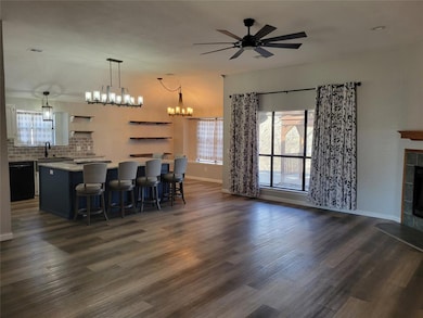 Open concept kitchen featuring dark wood-type floo