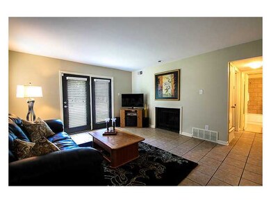 Roomy Den with Cozy Gas Fireplace.  Hallway leads 