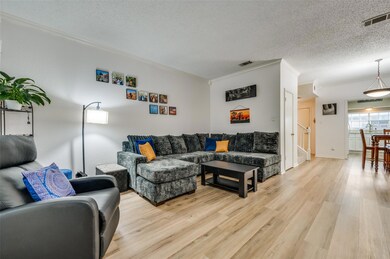 Living room featuring ornamental molding, a textur