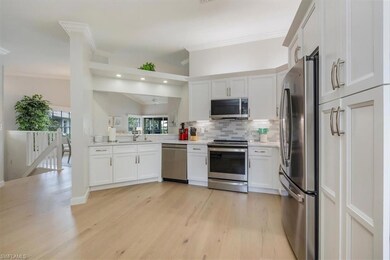 Kitchen with appliances with stainless steel finishes, backsplash, light wood finished floors, light countertops, and crown molding