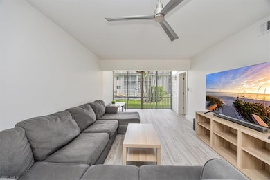 Living area with light wood-style floors and a ceiling fan