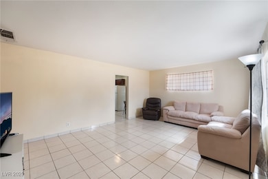 Living area with light tile patterned floors and baseboards