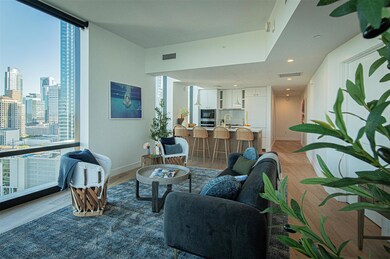 Living area featuring visible vents, a wall of wi