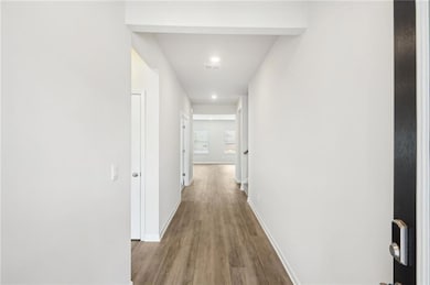 Corridor featuring wood finished floors and recessed lighting