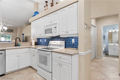 Kitchen with white appliances, white cabinets, and