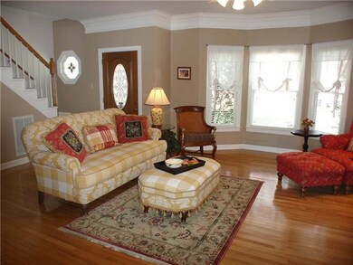Great room with bay window and entry with leaded glass wood door and storm door with screen.