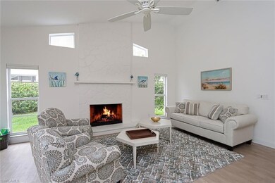 Living room with ceiling fan, a stone fireplace, w