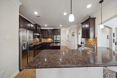 Spacious kitchen with dark wood cabinets, granite