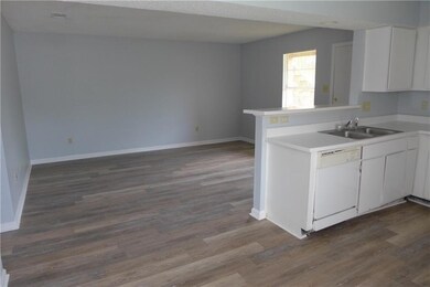 Kitchen featuring dishwasher, a sink, dark wood-s